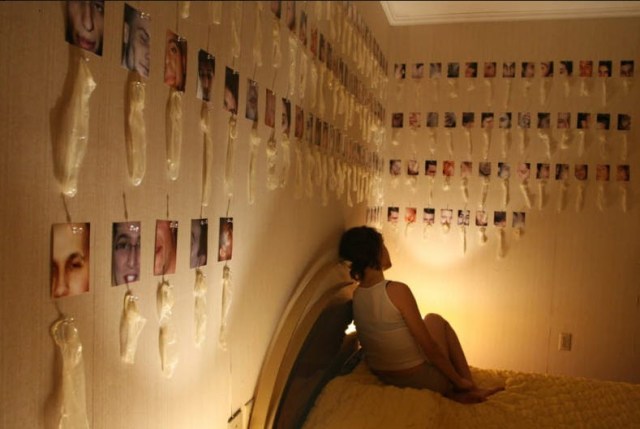 woman in bedroom with pictures attached to used condoms